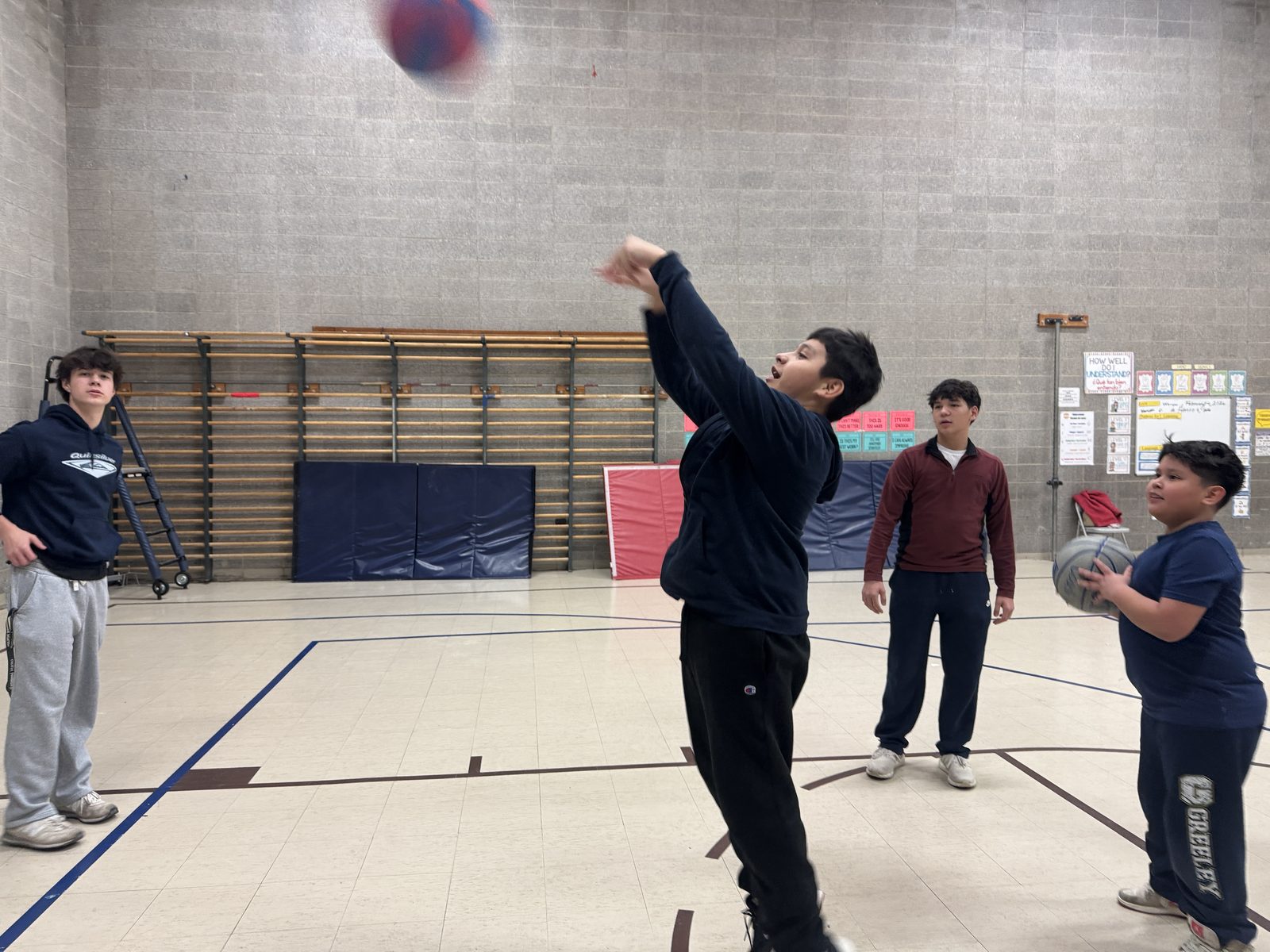 A student jumping mid-air for a basketball shot at Horace Greeley
