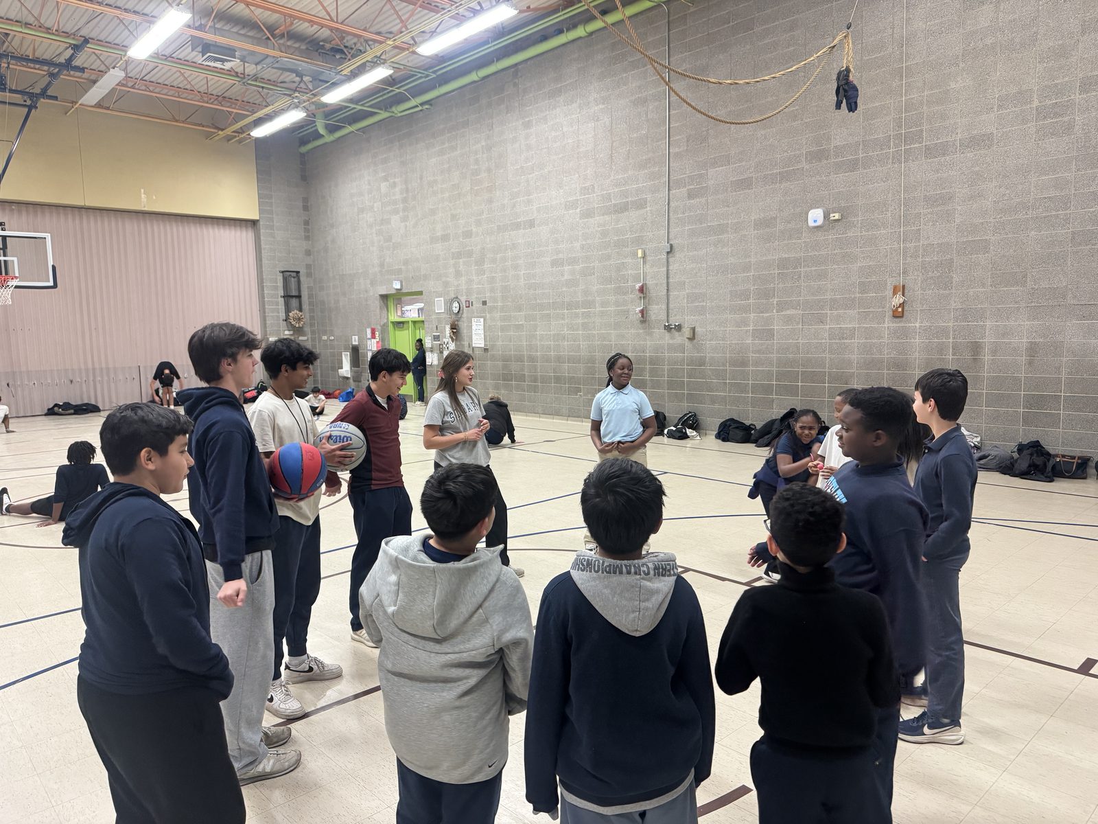 Volunteers and students in a circle during a clinic huddle